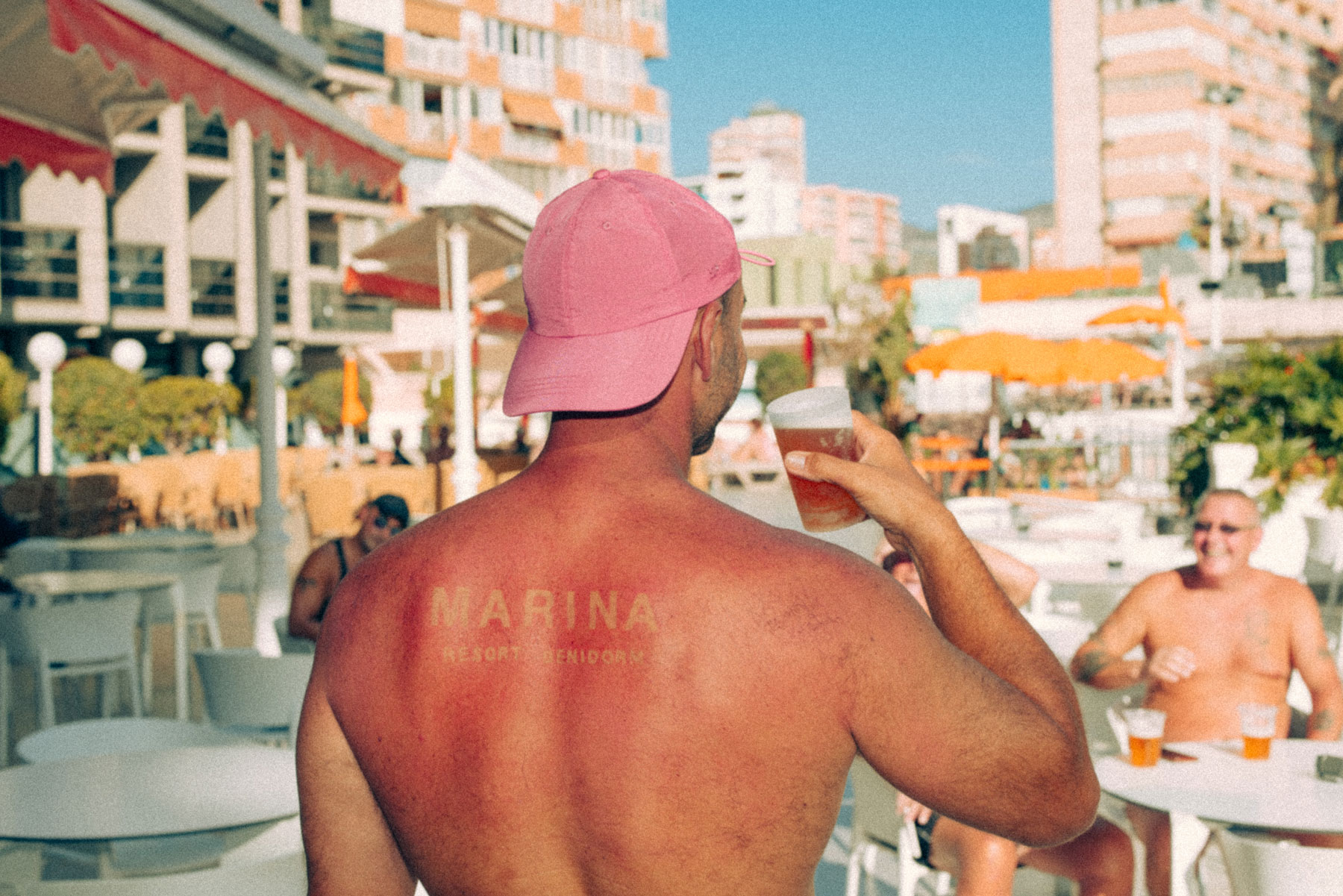 Sunburned man drinking and relaxing at Marina Resort Benidorm, epitomizing The Original Benidorm Vibe of carefree Mediterranean fun.